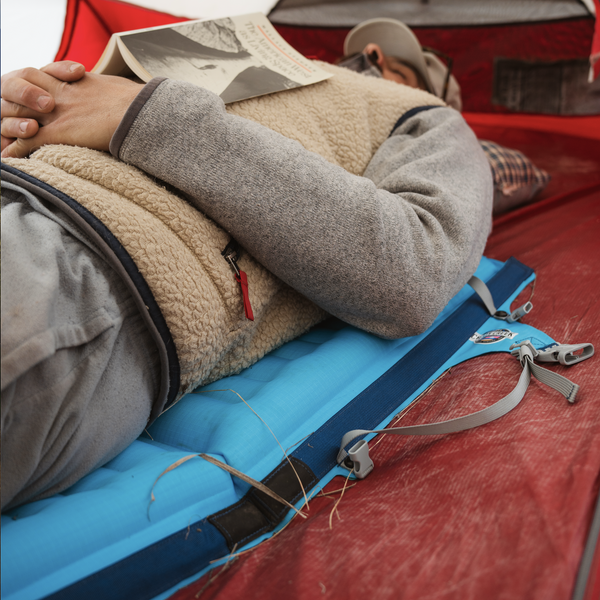 Man laying down on the AirCliner using it as a sleeping pad in a tent