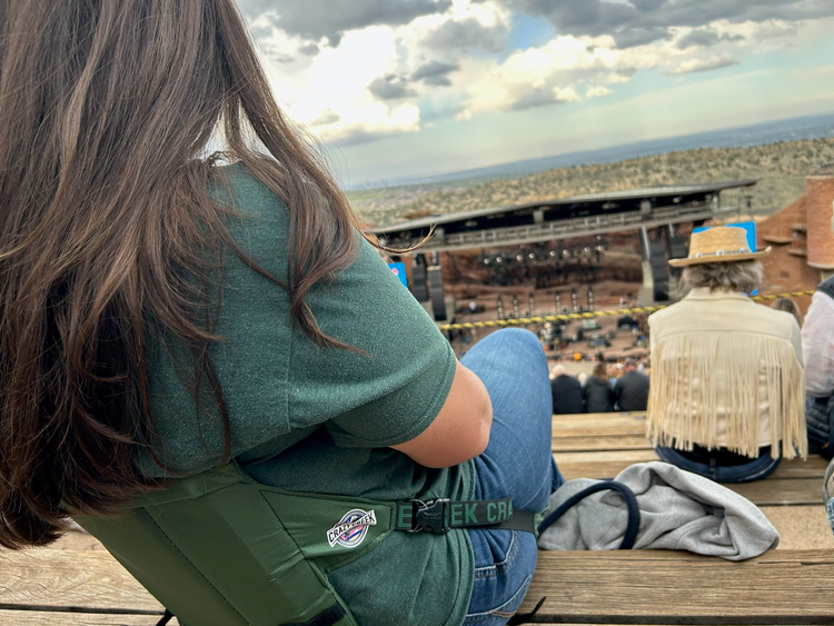 woman in crazy creek at red rocks concert