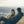 Two people laughing and talking sitting in chairs on the top of a mountain at sunset