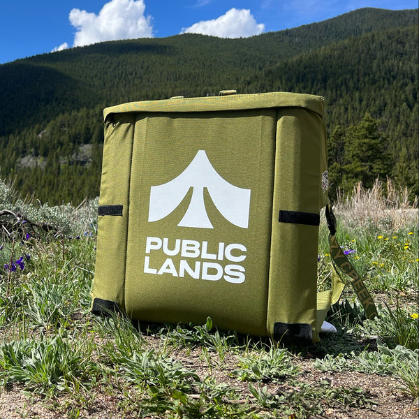 Green chair with 'Public Lands' logo screen printed on it in a mountainous landscape