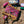 Floral-patterned Crazy Creek camping chair on a gravel surface with a small table in the background.